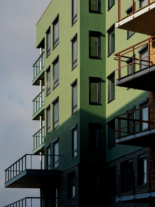 Foto av en grønn fasade på et nybygg på Vollebekk i Oslo.