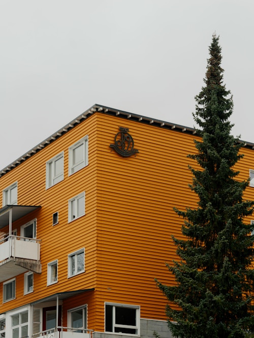 Foto av den karrakteristiske gule fasaden på Casinetto Borettslag på Frogner. OBOS-logen er synlig oppe i det ene hjørnet av bygget.