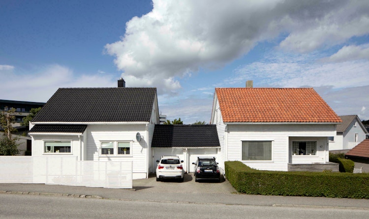 Bildet viser to hvite Block Watne-hus ved siden av hverandre, hvor det ene har svart tak og det andre har rød taksten.