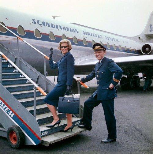 Foto av to SAS-ansatte med uniform i flytrapp på flyplassen på Fornebu.