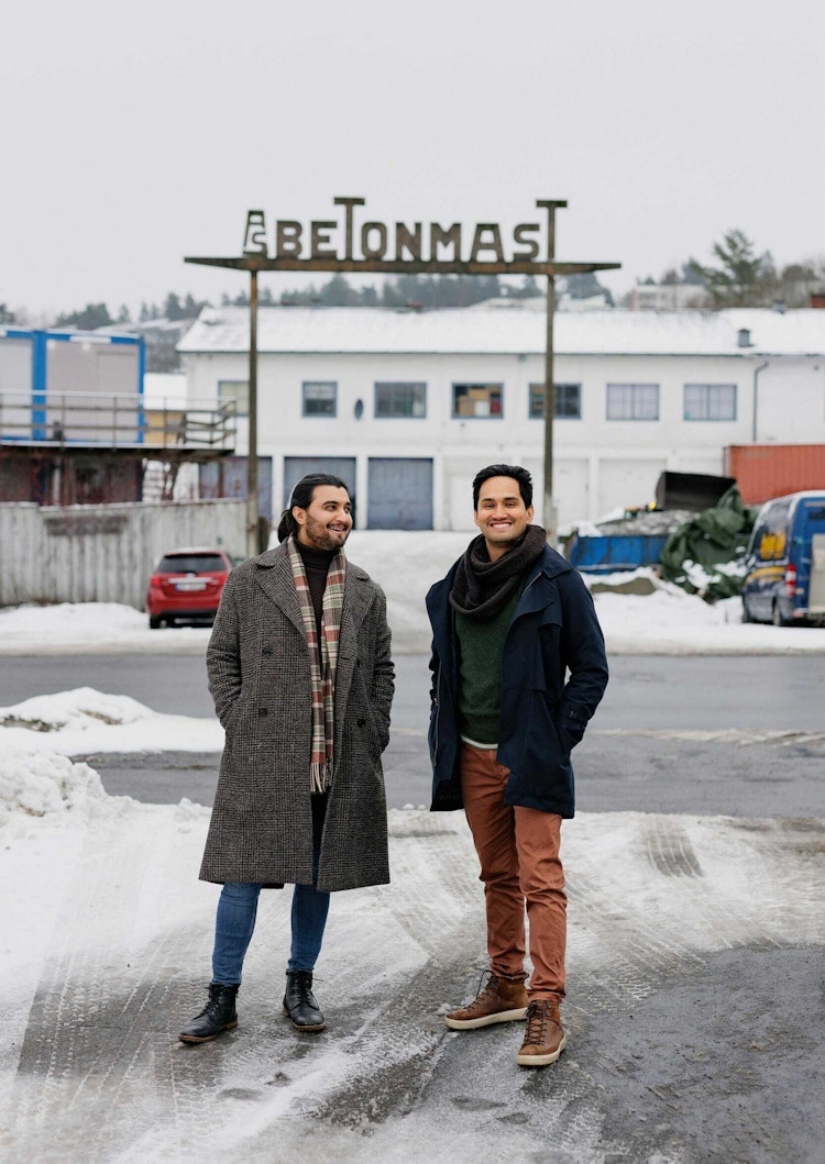 Foto av Mario Vahos og Osman Ilyas foran et skilt til Betonmast.