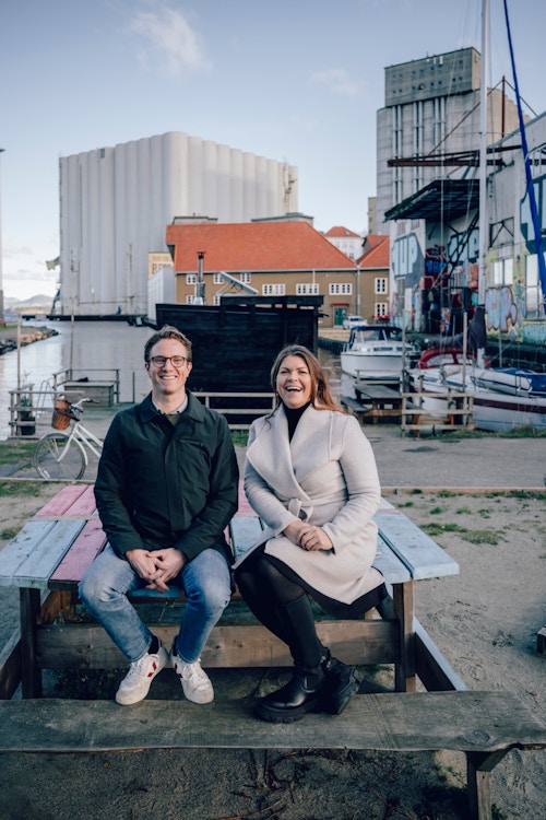 Foto av Hilde Jensen og Markus Stensholt på en benk på Badedammen Brygge.