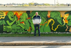 Ole Morten Øversjøen, daglig leder i Tveita borettslag, står foran grafittiveggen som viser flere av de som bor i borettslaget.