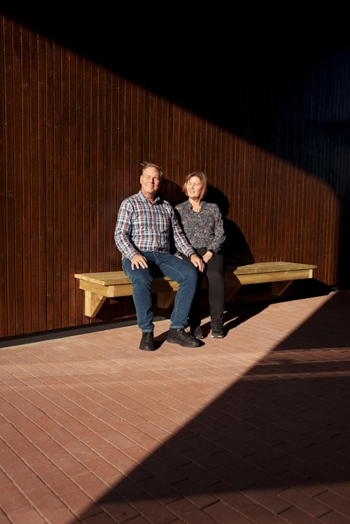 Nina og Lars Iver Wiig sitter på en krakk i portalgangen i Lumanders hage