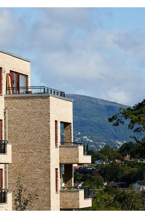 Foto av fasaden til Sandsliåsen med balkonger og utsikt.