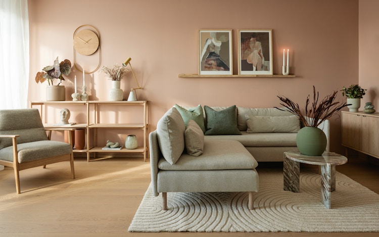 Visningsleilighet på Vollebekk, stue med sofa rosa vegger og interiørdetaljer.