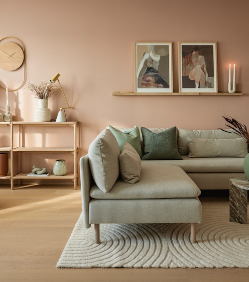 Visningsleilighet på Vollebekk, stue med sofa rosa vegger og interiørdetaljer.