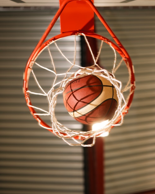 En basketball svever inne i basketkurven.
