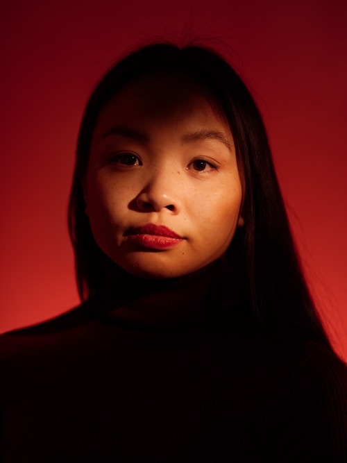 Stående portrettfoto av Catharina Vu mot mørkerød bakgrunn.