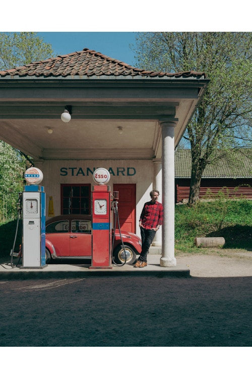 Fotografi av Odd Nordstoga ved en gammel bensinstasjon på Norsk Folkemuseum