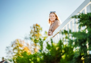 Foto av Kristina på en balkong i sola