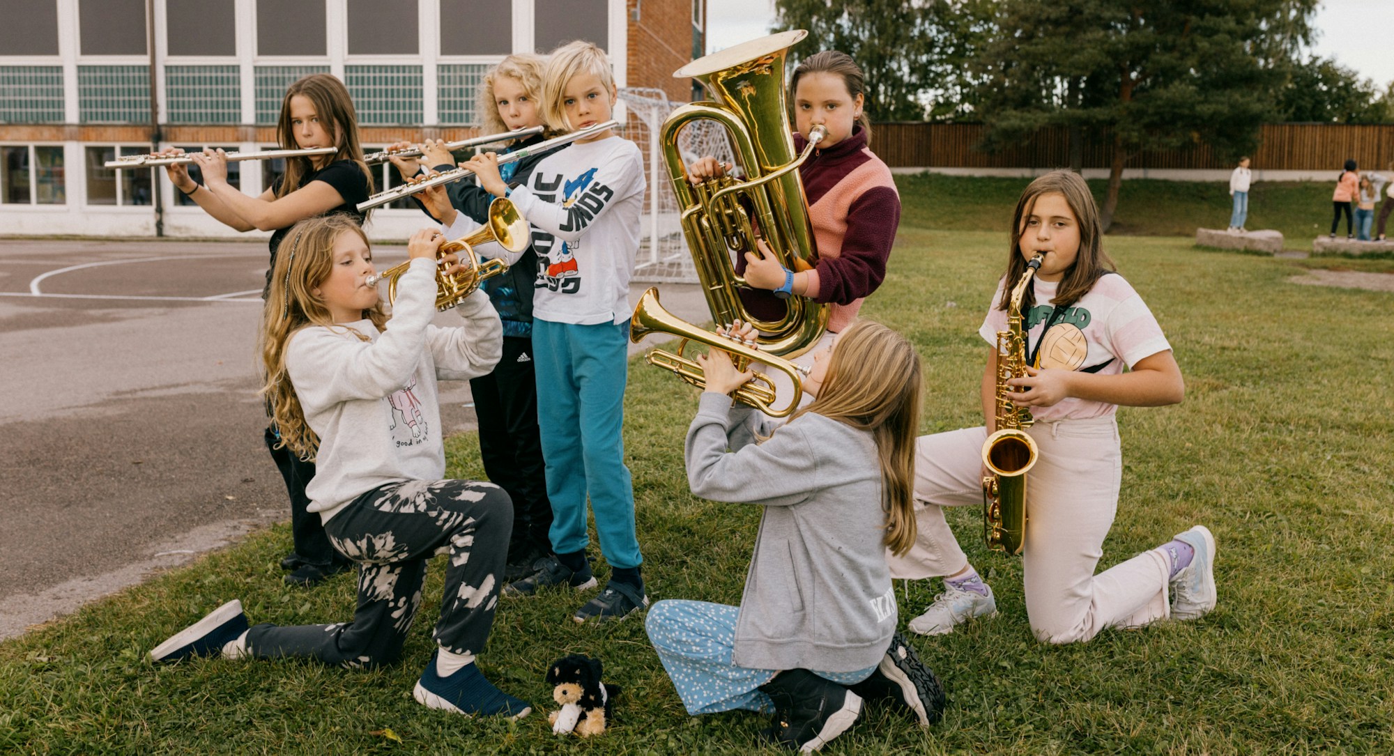 Noen av de unge musikantene i Lillestrøm skolekorps spiller på instrumentene sine utendørs.