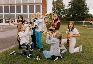 Noen av de unge musikantene i Lillestrøm skolekorps spiller på instrumentene sine utendørs.