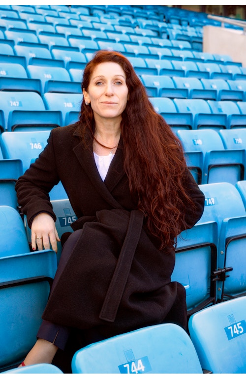Portrett av Lise Klavenes som sitter på en av de blå tribunestolene på Ullevaal Stadion.