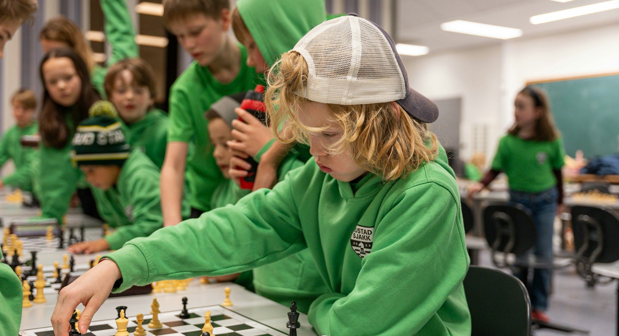Bilde av flere barn og ungdom i Rustad Sjakklubb som møtes for å spille sjakk.