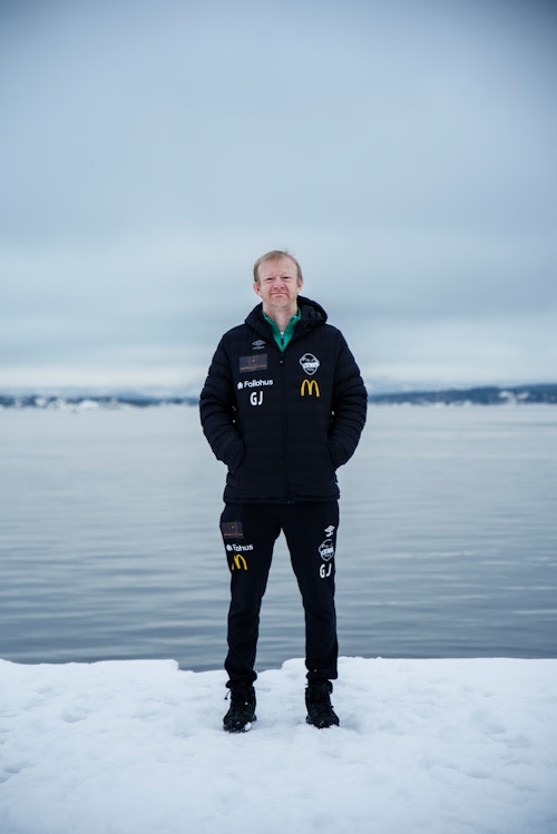 Bilde av Geir ute i snøen foran vannet. Han har på seg treningstøy.