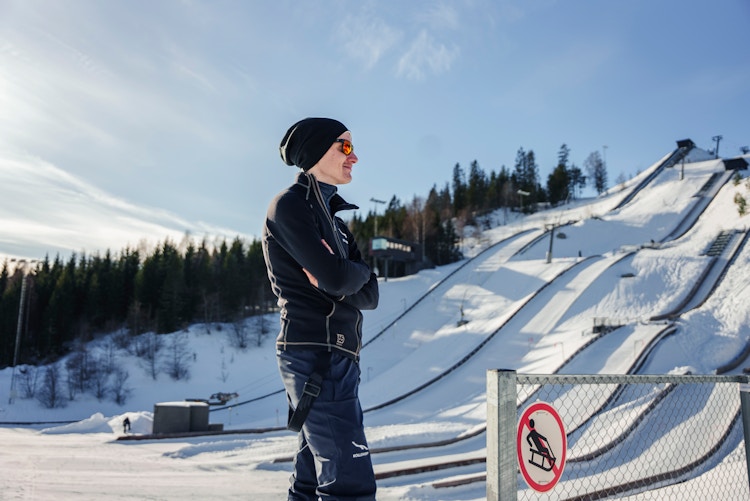 Instruktør Jørgen Madsen speider oppover Midtstulia rekruttanlegg mot en blå himmel og en snødekt bakke.
