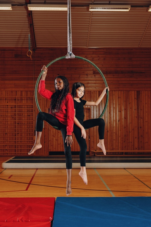 To unge akrobater sitter inne i en akrobatring