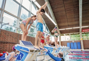 Foto av flere barn ved stupebrettene i svømmehallen på Lambertseter.