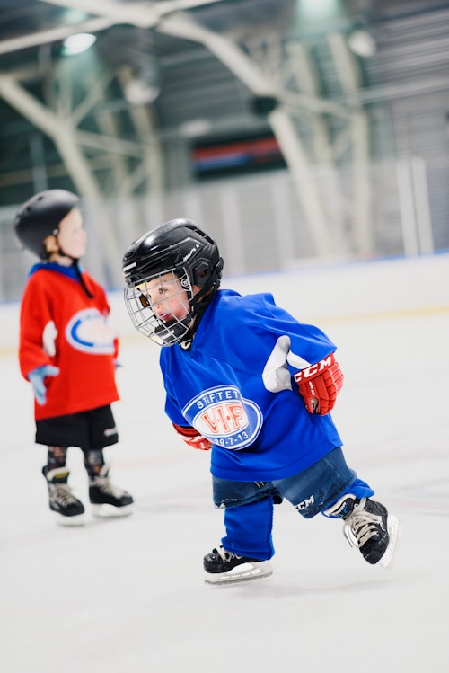 Foto av et lite barn med hockeyutstyr og VIF-drakt