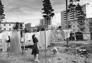 Arkivfoto fra Oslo kommune som viser en kvinne som henger opp klesvasken i bakgården.