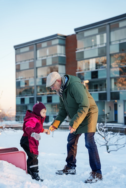 Foto av bestefar Svein som leker med barnebarnet sitt på lekeplassen.