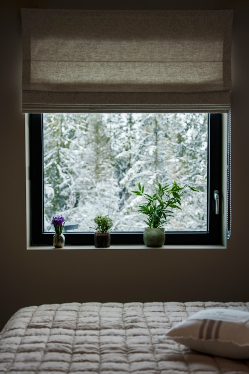 Soveromsvinduet til Elsa og Tore Moen som viser ut mot de snødekte trærne like utenfor.