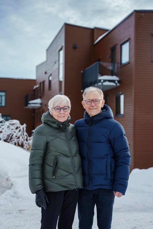 Elsa og Tore Moen utenfor leiligheten sin på Vitigrend, omgitt av snø og en klar himmel.