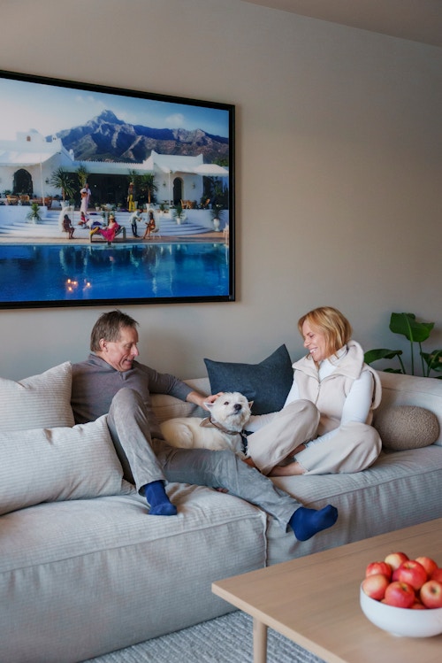 Bilde av Ann-Christin og Frank og hunden deres som sitter sammen i en sofa