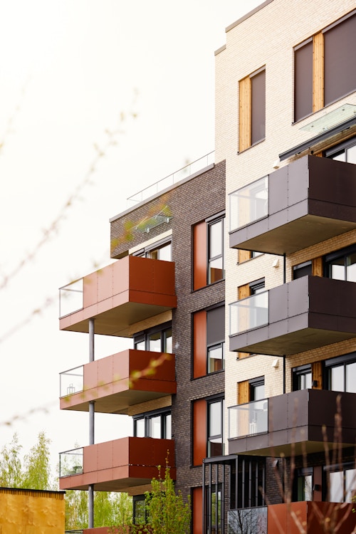 Oransje og brune balkonger langs fasaden til et leilighetsbygg i Storøykilen