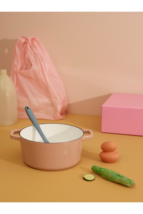 Bilde av en rosa kasserolle med en sleiv i, en rosa pose, en agurk og noen egg, tatt i studio.