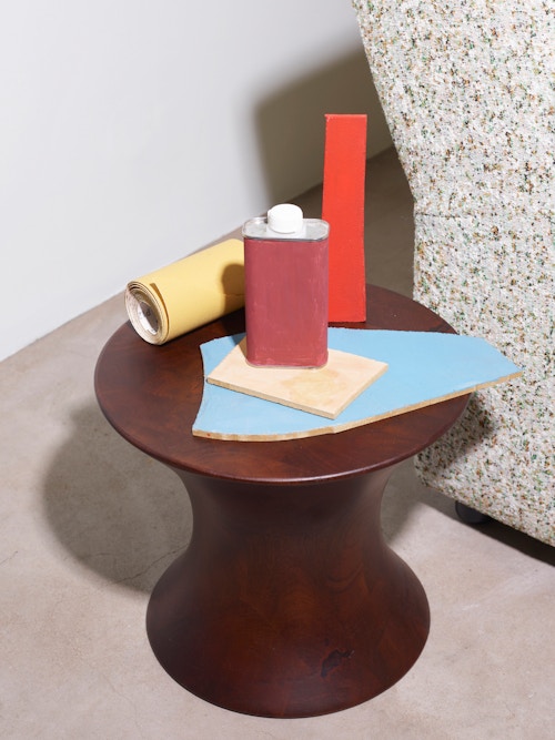 Sandpapir, materialer og en liten boks er plassert på et lite sidebord.
