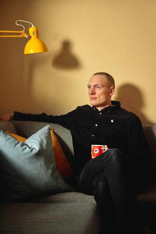 Portrett av Håkon Winje som sitter i sofaen i stua.