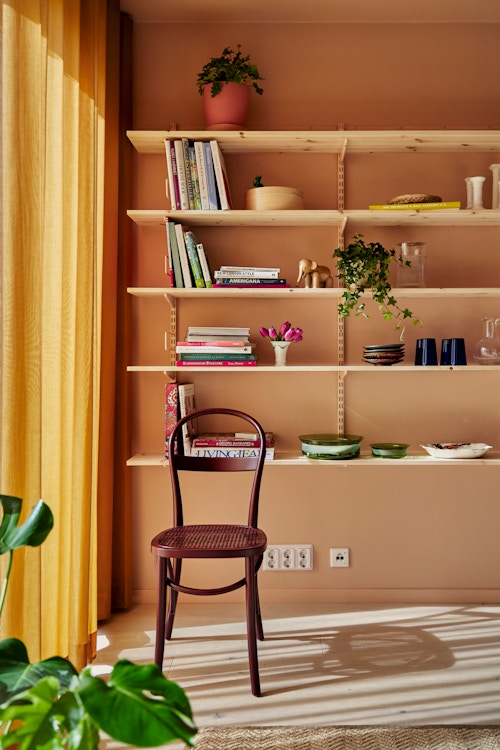 Bildet viser deler av oppholdsrommet med bokhyller i leiligheten.