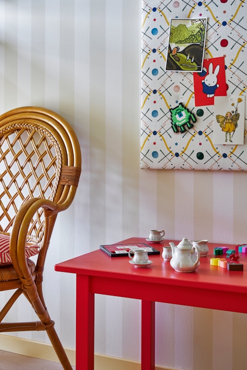 Bildet viser et bord med noen leker og en stol i barnerommet.
