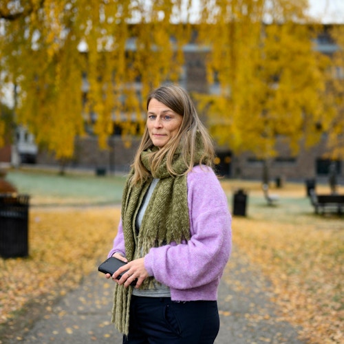 Rådgiver for velferdsteknologi i Elverum kommune, Åshild Sæther Engen, står utendørs utenfor rådhuset i Elverum. Det er høst og gule blader dekker bakken rundt henne,