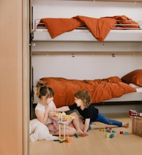 Foto av to barn som leker på gulvet på et barnerom i OBOS Living Lab