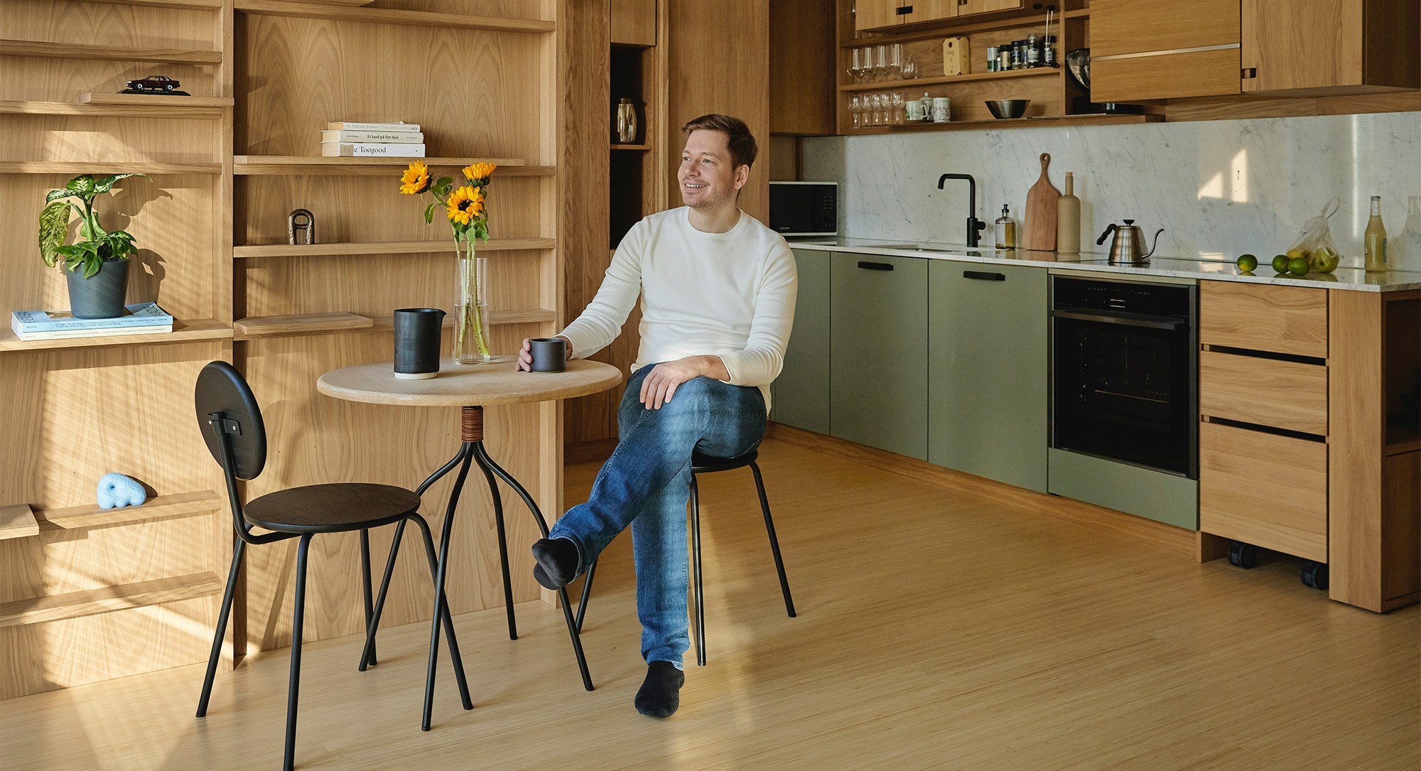 Foto av Aslak Heggland sittende på en stol kjøkkenet