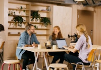 Foto av tre personer som sitter rundt et bord og jobber i OBOS Living Lab