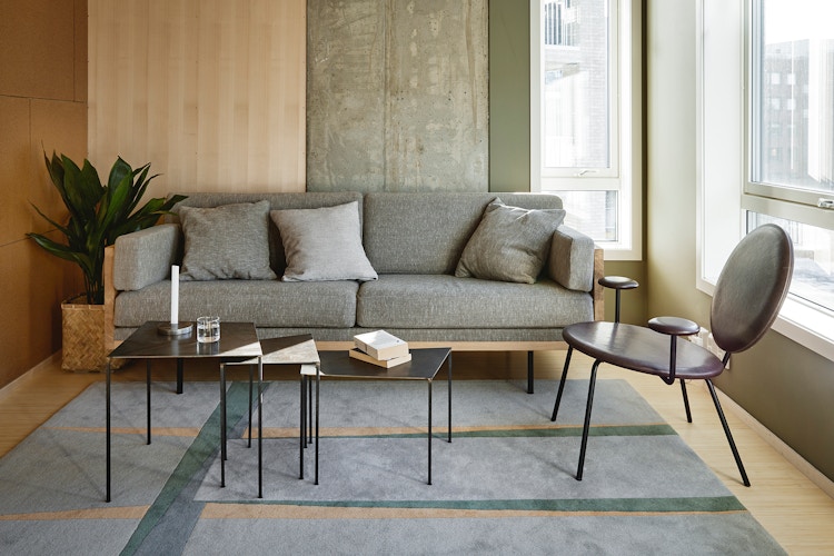 Foto av en grå sofa, sofabord og stol i en stue i OBOS Living Lab.