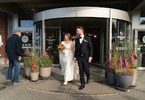 Brudeparet forlater kjøpesenteret som nygift og hilser på andre besøkende som skal gjøre sine daglige ærend.