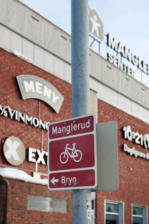 Foto av et sykkelskilt som viser retning fra Manglerud mot Bryn.