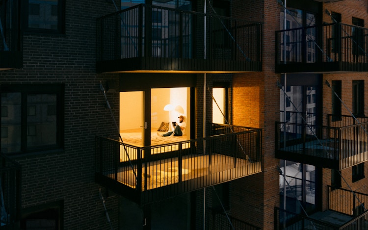 Bildet viser en fasade på Ulven, hvor en leilighet er opplyst.
