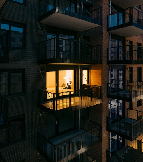 Bildet viser en fasade på Ulven, hvor en leilighet er opplyst.