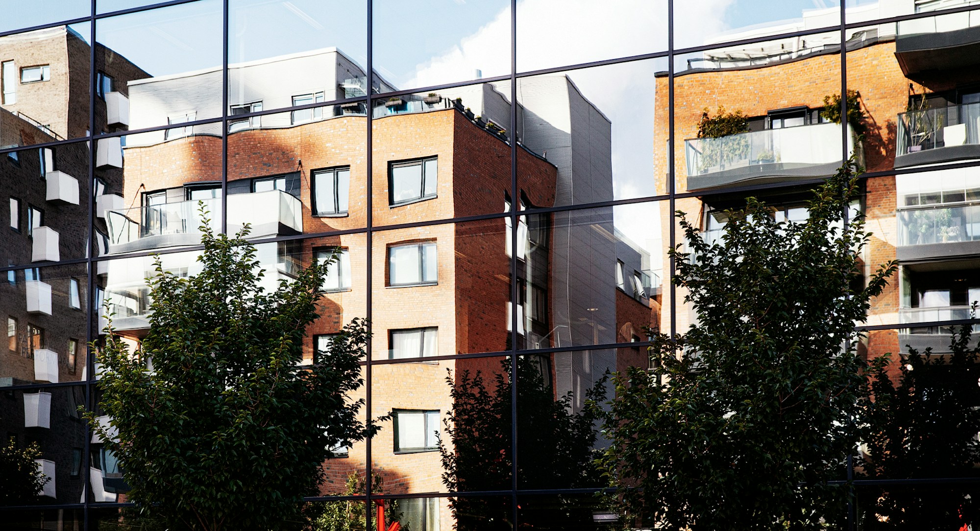Bilde fra Kværnerbyen, hvor noen bygg speiler seg i glasset på et over veien.