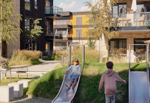 To barn på en lekeplass med sklier i et gårdsrom på Fornebu.