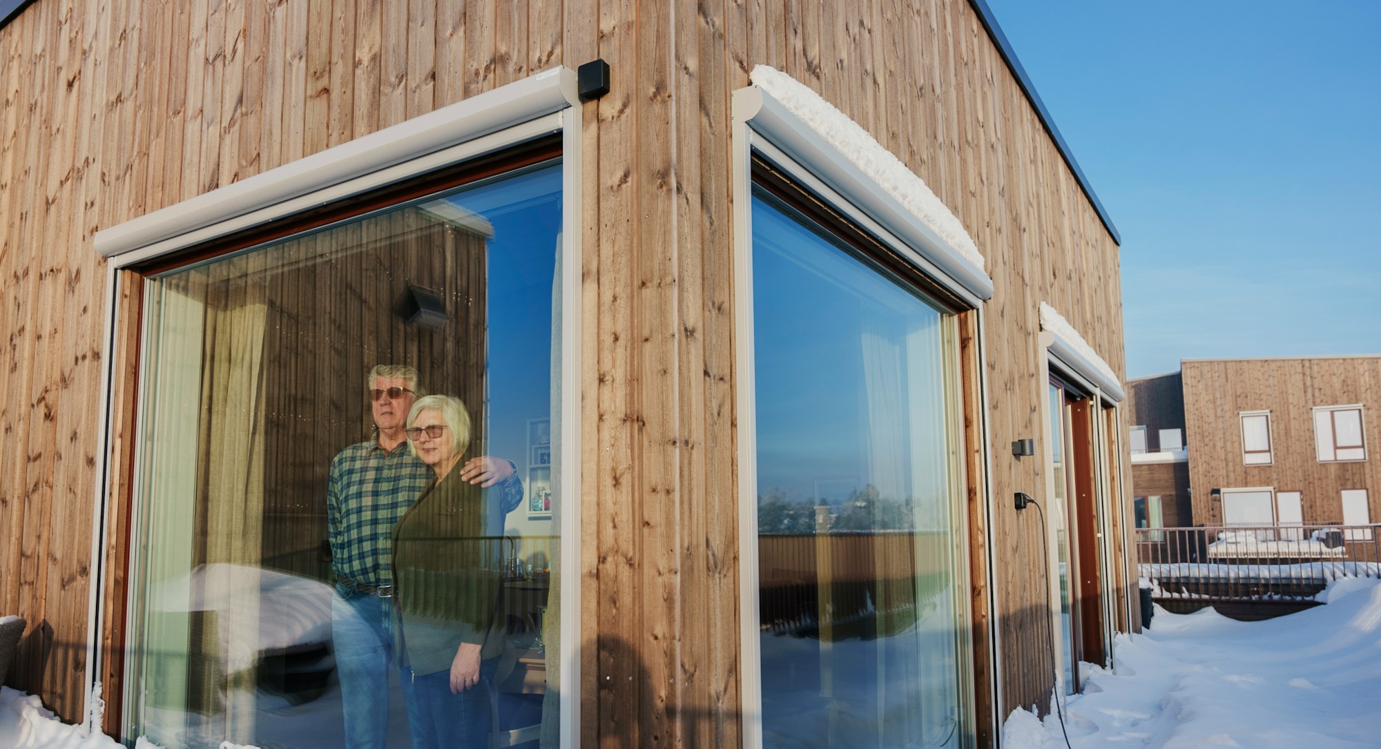 Åge og Inger Lise ved vinduet i stuen sin.